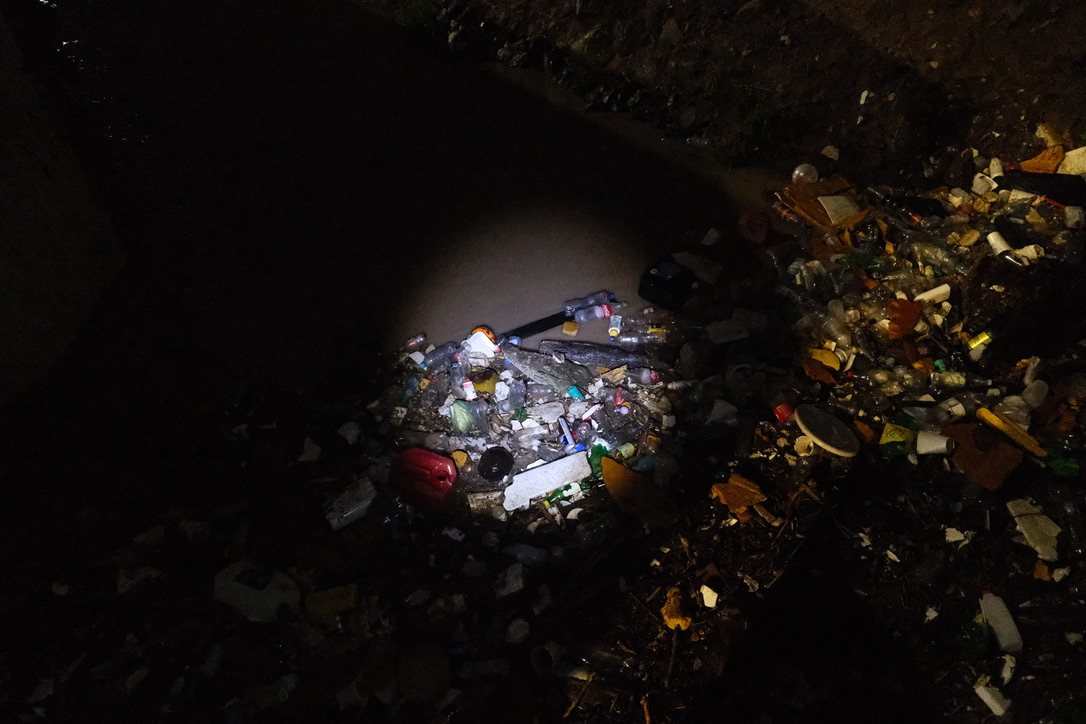 Basura acumulada en el canal de noche